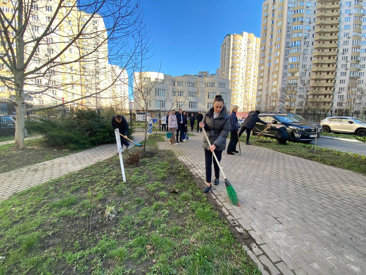 Працівники ЦНАП Києва прибирають територію під час весняної толоки – збирають сміття, працюють з інвентарем, висаджують рослини